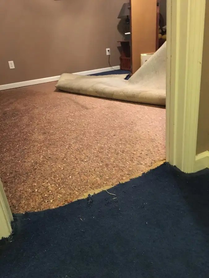 Carpet pad removal revealing water damage during Water Mitigation Services in Huntsville